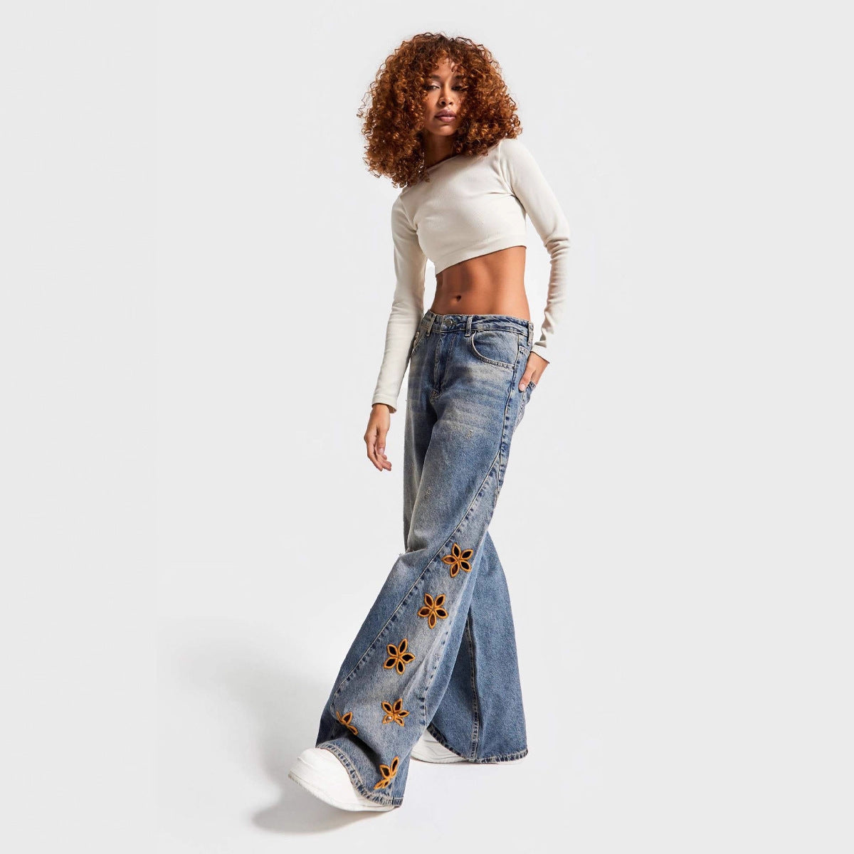 Jean femme taille haute coupe ample à motifs floraux ajourés