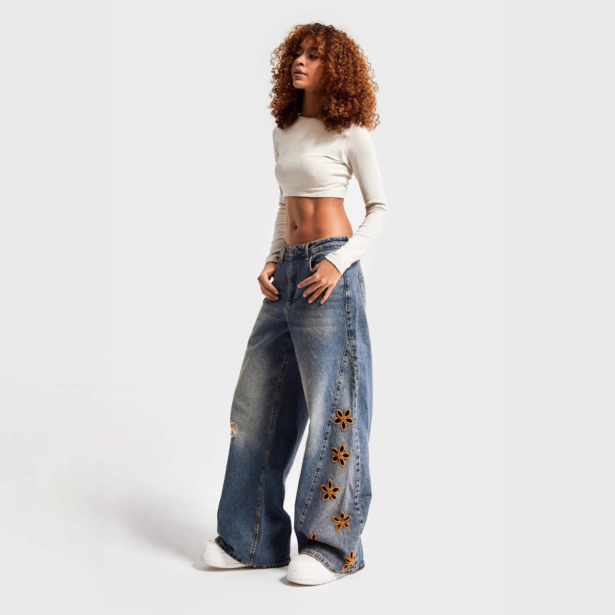 Jean femme taille haute coupe ample à motifs floraux ajourés