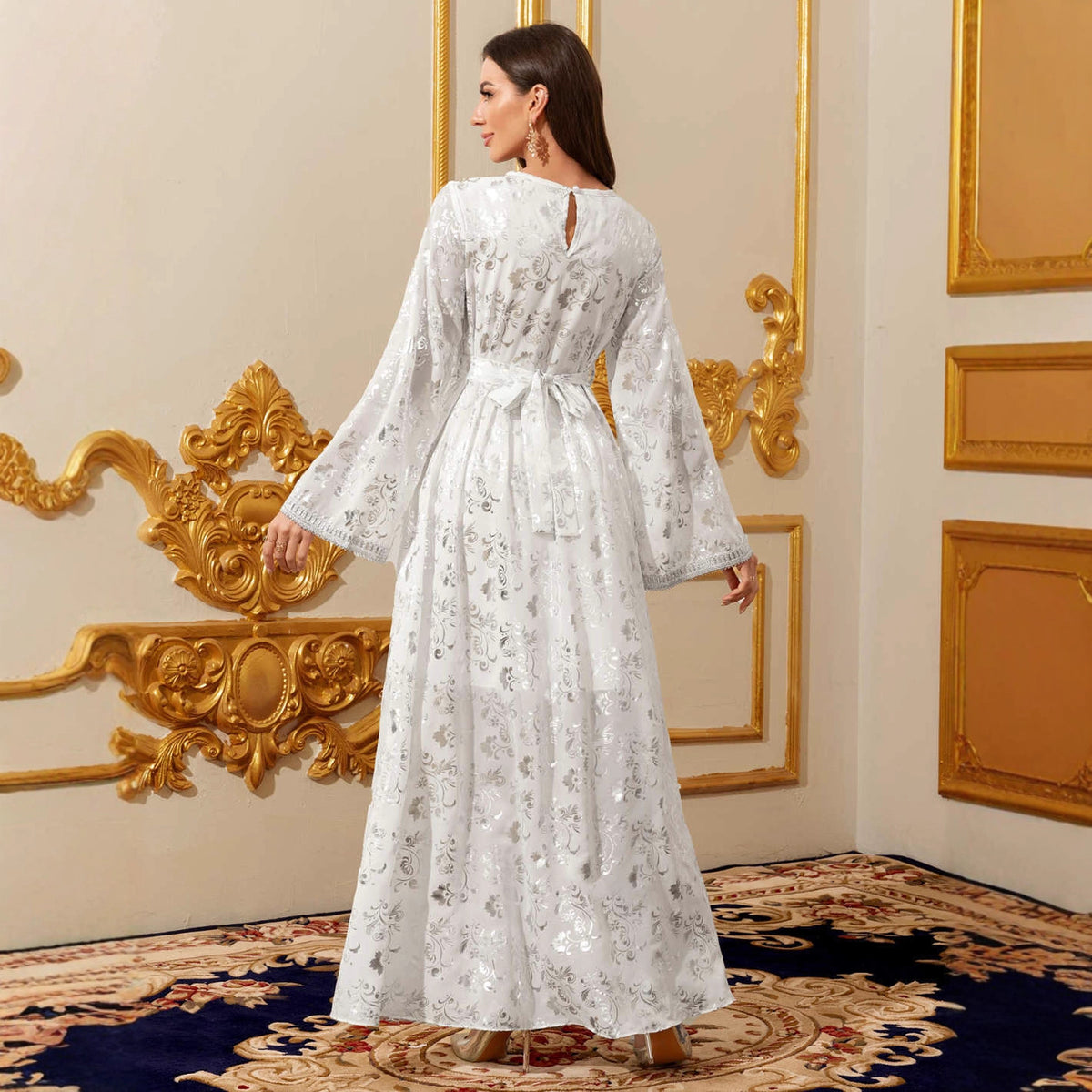 Robe longue blanche à manches longues et motifs dorés