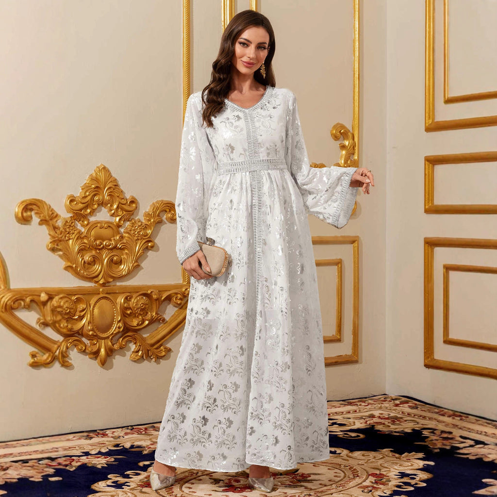 Robe longue blanche à manches longues et motifs dorés